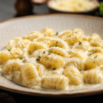 Nhoque ao molho de Catupiry cremoso finalizado com parmesão e manjericão